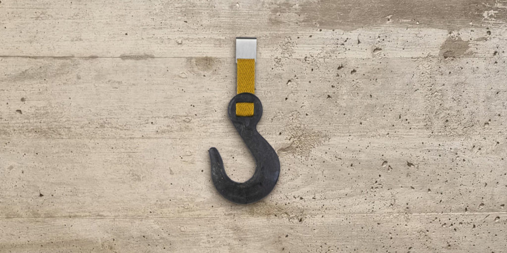 storage hook with yellow strap on a cement wall